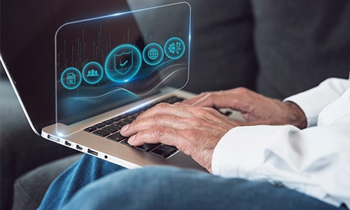Person using laptop with cybersecurity icons